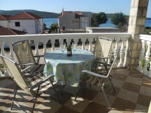 una mesa con una botella de vino en el balcón en Apartments Maca - seaview & private parking, en Zablaće