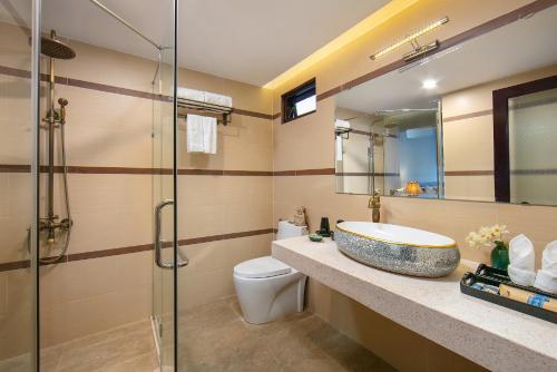 a bathroom with a sink and a toilet and a shower at La Charm Hoi An Hotel & Spa in Hoi An