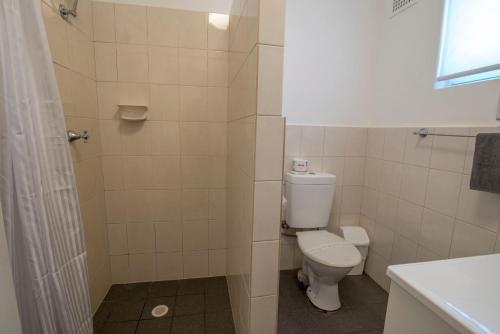 a bathroom with a toilet and a shower at Bermagui Motor Inn in Bermagui