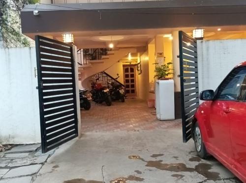 a garage with a red car parked in front of it at Le Grace Mansion in Madurai