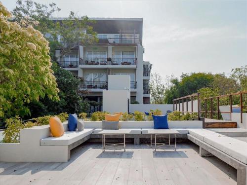 a patio with a couch and chairs and a building at RELO' The Urban Escape - Huahin in Cha Am