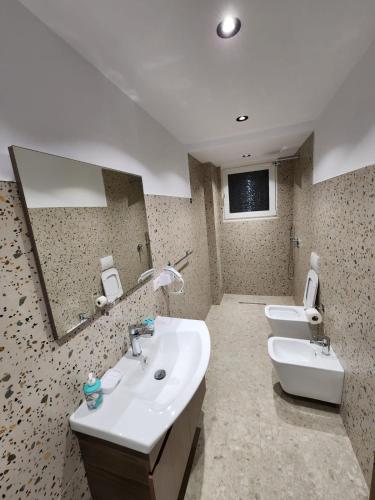 a bathroom with two sinks and two mirrors at Pietro Guesthouse in Tirana