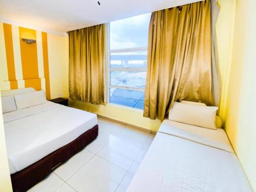 1 Schlafzimmer mit 2 Betten und einem großen Fenster in der Unterkunft Sun Inns Hotel Puchong in Puchong