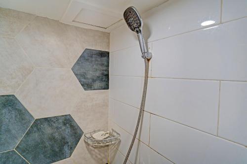 a shower with a shower head in a bathroom at OYO Life 92976 Apartement Jarrdin By Apato in Bandung