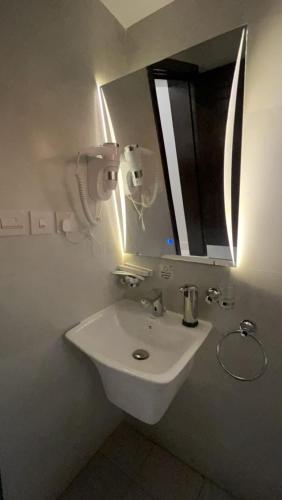 a bathroom with a white sink and a mirror at روشن الماسي للشقق المخدومة in Yanbu