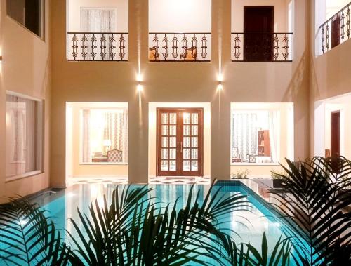 a house with a swimming pool in a room with windows at Chez Lavania - A Boutique Homestay in Udaipur