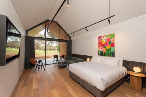 a bedroom with a bed and a living room at Par Five Shacks in Berri