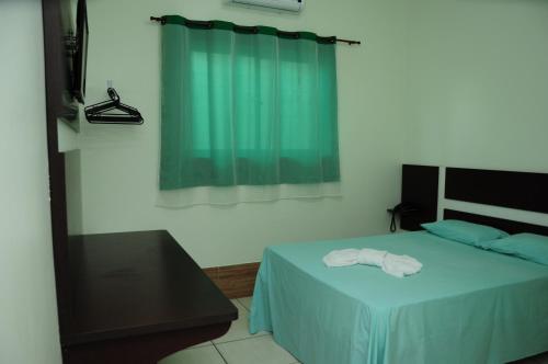 a bedroom with a bed with a towel on it at Eder Hotel in Cacoal