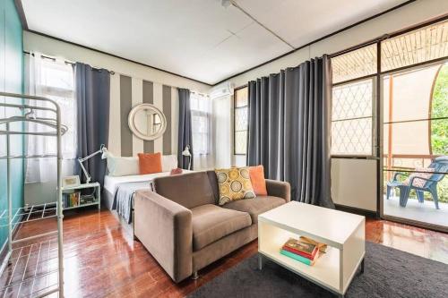 a bedroom with a bed and a couch and a chair at Bang Chak Homestay in Amphoe Phra Khanong