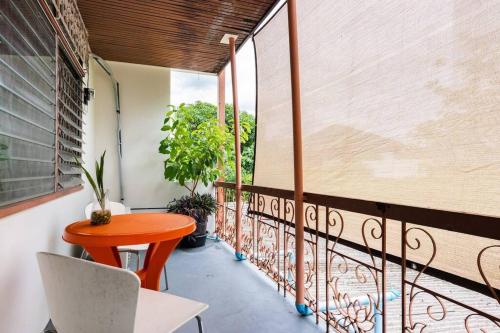 a balcony with a orange table and a chair at Bang Chak Homestay in Amphoe Phra Khanong