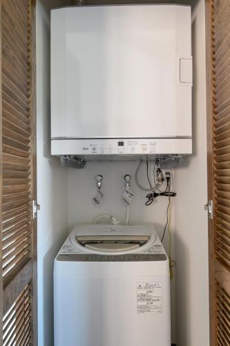a washer and dryer with a microwave above it at ホテルコンドミニアム土花土花 in Onna