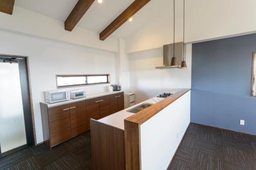 a kitchen with a sink and a counter top at ホテルコンドミニアム土花土花 in Onna