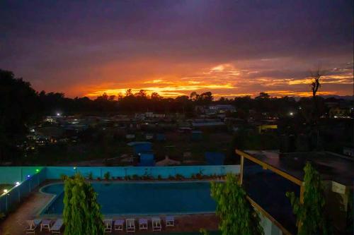 a sunset over a swimming pool at a resort at Hotel Opera in Bahāsi