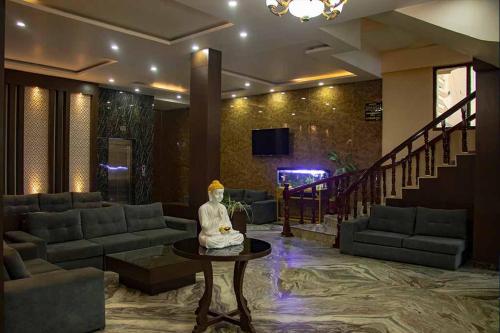 a lobby with a couch and a table with a statue at Hotel Opera in Bahāsi