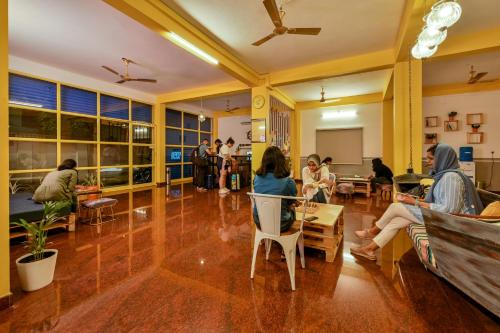 grupa ludzi siedzących w salonie w obiekcie The Hosteller Fort Kochi w mieście Koczin