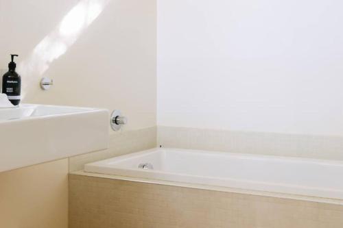 d'une baignoire blanche installée à côté d'un lavabo. dans l'établissement Parsons Cove Beach House, à Coles Bay