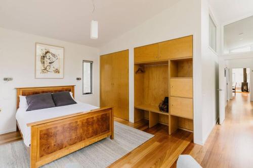 a bedroom with a large bed and wooden cabinets at Parsons Cove Beach House in Coles Bay
