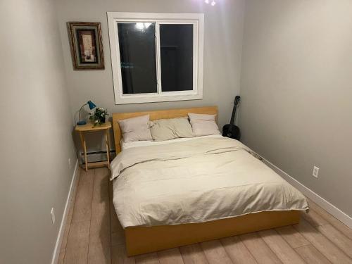 a small bedroom with a bed and a window at Perfect Stays in Edmonton