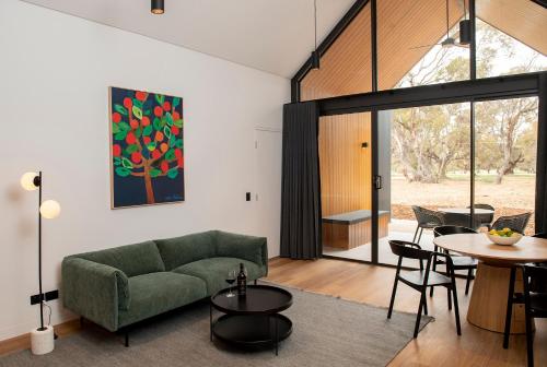uma sala de estar com um sofá verde e uma mesa em Par Five Shacks em Berri