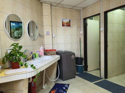 SPOT ON 90856 Arriva Travellers في كوتشينغ: حمام مع حوض ومرآة