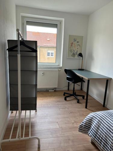 a room with a desk and a table and a chair at Monteurwohnung I WLAN I Einzelbetten in Burgneudorf