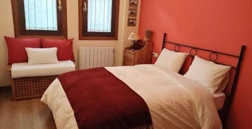 ein rotes Schlafzimmer mit einem großen Bett und einem Stuhl in der Unterkunft El Boj AVAIRENT Canfranc Pueblo in Canfranc