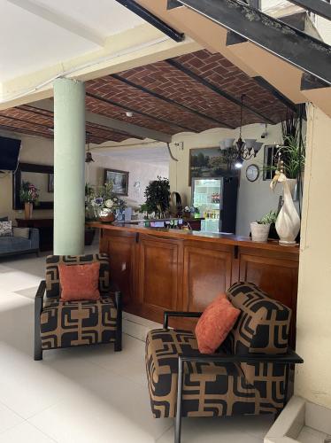 a living room with two chairs and a counter at Hotel Cañada's & Bungalows in Villa Corona
