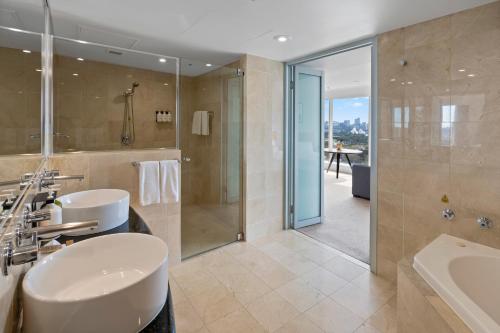 a bathroom with a sink and a shower and a tub at Holiday Inn Sydney Potts Point in Sydney