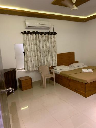 a bedroom with two beds and a window at Tarkarli Resort Ganpat Prasad in Malvan