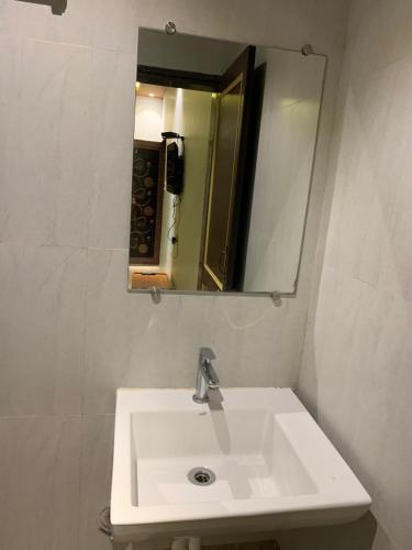a white sink in a bathroom with a mirror at Tarkarli Resort Ganpat Prasad in Malvan