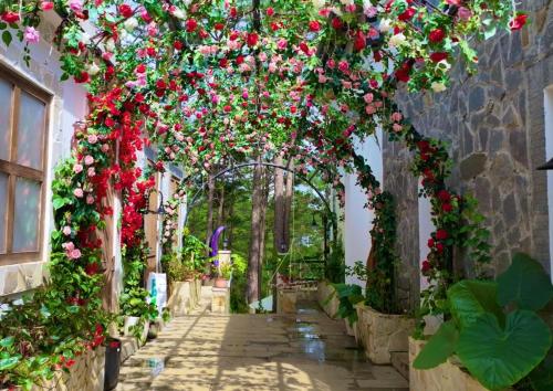 an archway covered in flowers in a garden at De Vivre Homestay Măng Đen in Kon Von Kla