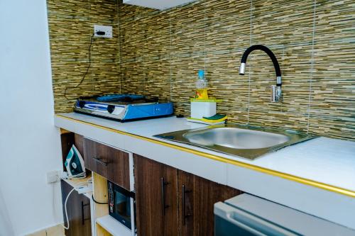 Serene Bliss Studio - Diani في أوكوندا: طاولة مطبخ مع حوض ومحمصة