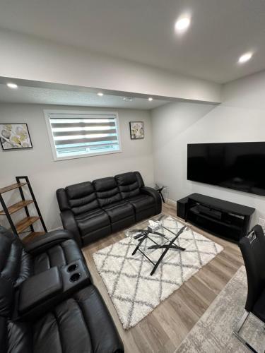 a living room with a couch and a flat screen tv at 2 Bedroom 2 Washrooms Brand New Beautiful & Cozy Suite in Calgary