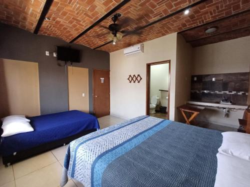 um quarto com uma cama azul e um lavatório em Hotel Cañada's Bungalows em Villa Corona