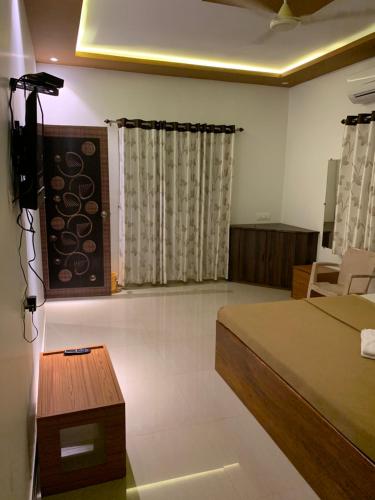 a bedroom with a bed and a table in a room at Tarkarli Resort Ganpat Prasad in Malvan