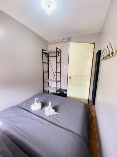 a bedroom with a bed with two towels on it at Cozy 2BR w/ Free Pool Access and Free Parking N224 in Manila