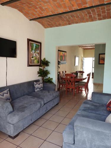 a living room with a couch and a dining room at Hotel Cañada's & Bungalows in Villa Corona