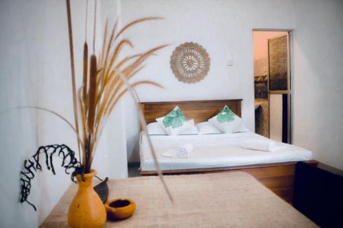 a bedroom with a bed and a vase on a table at Bananas Mirissa in Mirissa