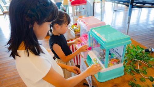 two young girls looking into a toy refrigerator at Matsue Forest Park in Matsue