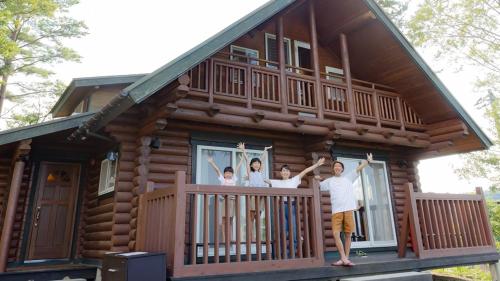 a group of people standing on the balcony of a log cabin at Matsue Forest Park in Matsue