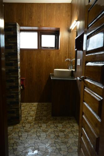 a bathroom with a sink and a window and a door at Utopia Hostels Dharamkot Mcleodganj in Dharamshala