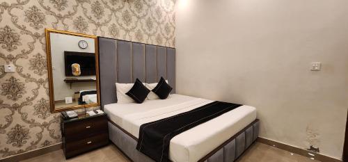 a bed in a room with a mirror and a bed sidx sidx sidx at Red Fort Hotel Gulberg in Lahore