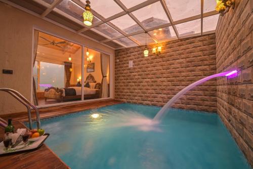 a indoor swimming pool with a water fountain at Jungle Lodge Resort in Kasauli