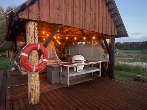 a gazebo with a table on a deck at Wiire old fishermans farmhouse and smoke sauna in Saulepa