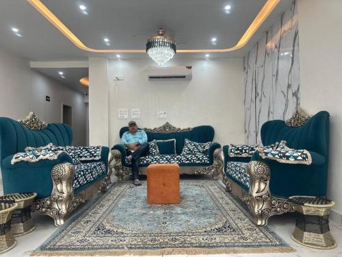 a man sitting on a couch in a living room at Hotel Yog Safari, Behind Parmarth Niketan in Rishīkesh