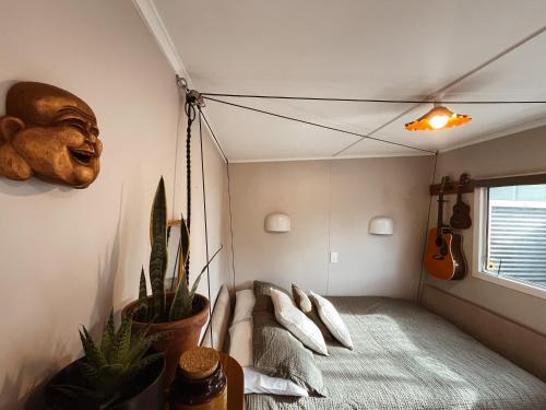 Habitación con cama columpio y guitarra en The Secret Studio, Outdoor Bath & Pizza Oven, en New Plymouth