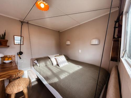 a small bedroom with a bed in a room at The Secret Studio, Outdoor Bath & Pizza Oven in New Plymouth