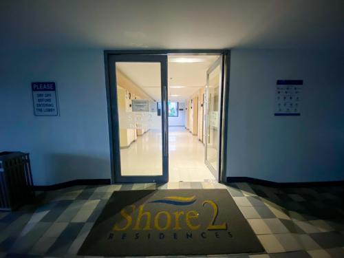 a store entrance with a sign in front of a door at Shore2 Luxurious & Homely Suite near MOA in Manila