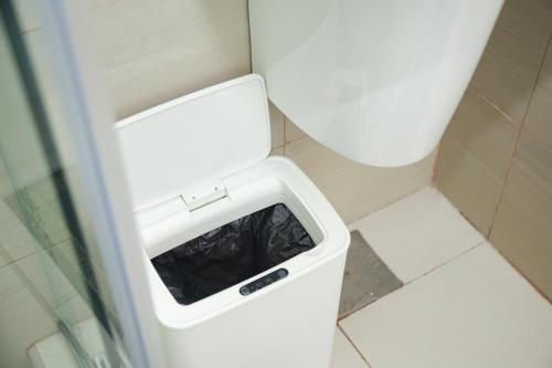 a bathroom with a toilet with a litter box at Shore2 Luxurious & Homely Suite near MOA in Manila