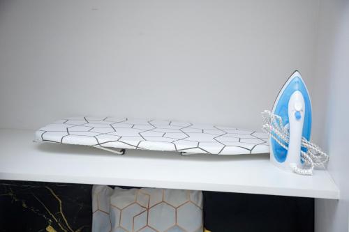 a white shelf with a pair of scissors on it at Shore2 Luxurious & Homely Suite near MOA in Manila